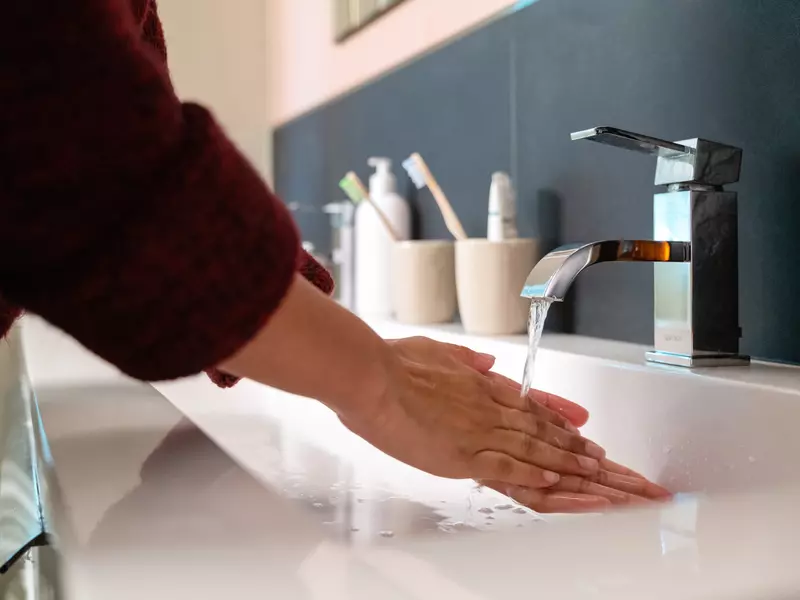 handen wassen vrouw onder de kraan