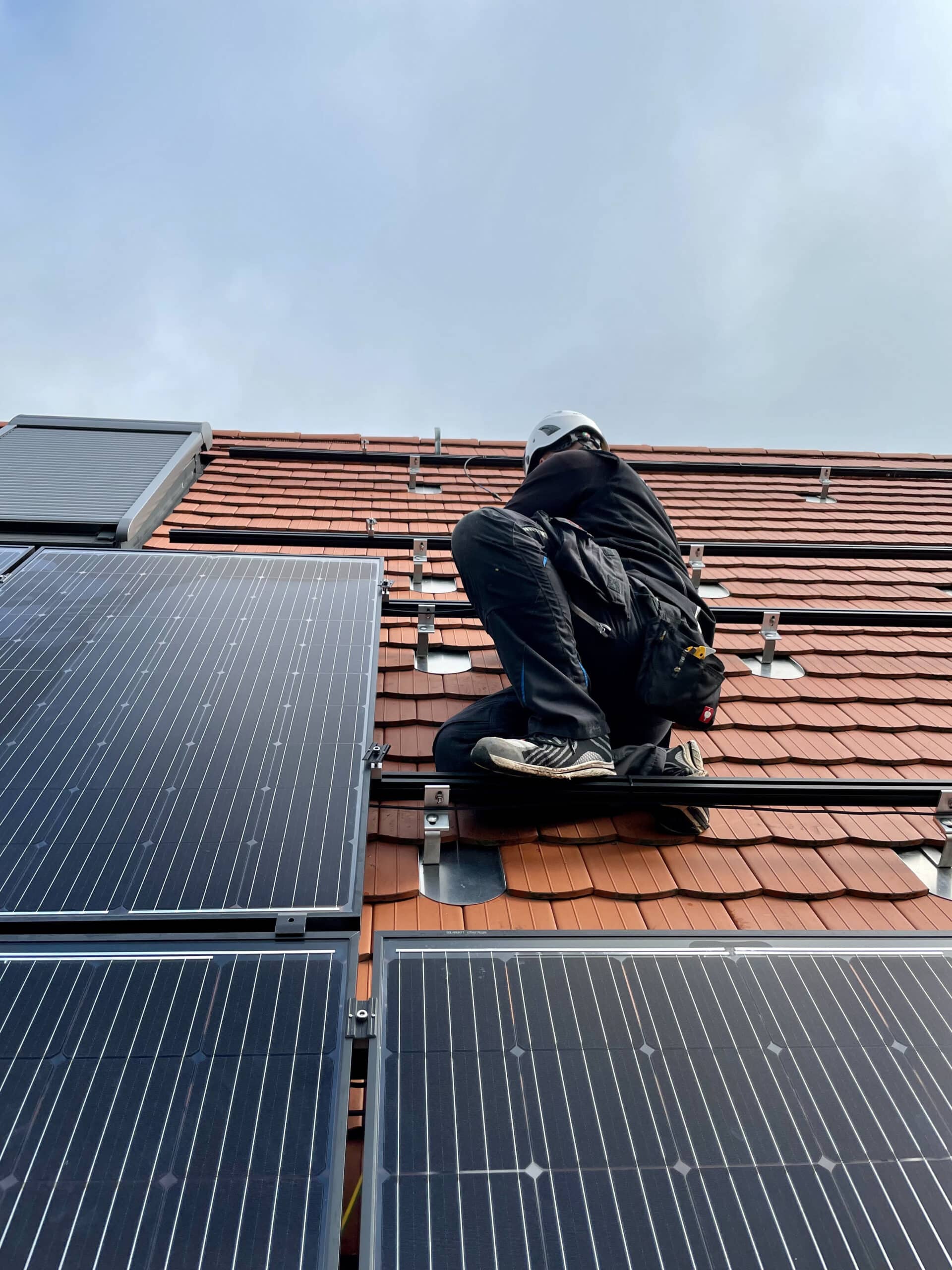 installateur op het dak met zonnepanelen